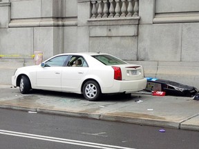 A Cadillac sits on the sidewalk of René-Lévesque Blvd. after crashing into the Sun Life Building near Metcalfe St. on Saturday, June 14, 2014.