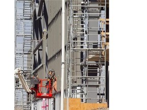 Soccer complex being built near the corner of Papineau Ave. and Louvain St. on Tuesday May 06, 2014. Picture shows worker on the north side of site working on outside wall of main building.