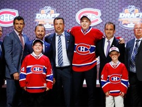 Nikita Scherbak stands with Canadiens officials after being chosen 26th overall during the first round of the NHL hockey draft on Friday in Philadelphia.