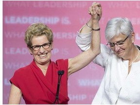 Ontario Liberal leader Kathleen Wynne celebrates in Toronto with partner Jane Rounthwaite after winning the provincial election on Thursday. Wynne’s victory also makes her the first female premier ever elected in the province, and the first openly gay premier in the history of Canada.