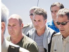 Left to right: Former Montreal, Maine & Atlantic Railway employees Thomas Harding, Jean Demaître and Richard Labrie (in blue) arrive at a courthouse in Lac-Mégantic on Tuesday, May 13, 2014. The three have been charged with 47 counts of criminal negligence causing death.