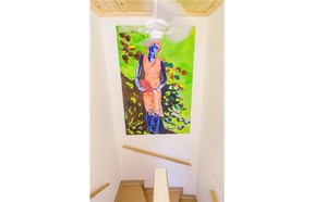 A painting hanging over the staircase towards the guest room.