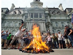 Public sector workers light a bonfire as they protest protest against proposed pension changes in front of City Hall Tuesday, June 17, 2014 in Montreal.