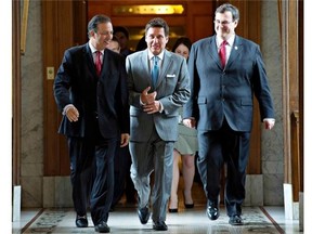 Quebec Municipal Affairs Minister Pierre Moreau, flanked by Quebec Labour Minister Sam Hamad, left, and Quebec Employment and Social Solidarity Minister Francois Blais, en route to a news conference to to talk about the pension bill, Thursday, June 12, 2014.