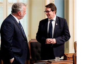 Quebec Premier Philippe Couillard chats with Opposition MNA Pierre-Karl Péladeau who attends debates for the first time after suffering from a major bicycle accident, Monday, May 26, 2014 at the legislature in Quebec City.