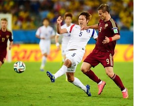 South Korea’s defender Kim Young-Gwon (L) vies with Russia’s forward Alexander Kokorin during a Group H football match between Russia and South Korea in the Pantanal Arena in Cuiaba during the 2014 FIFA World Cup on June 17, 2014.