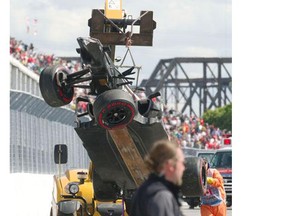 Sauber's Esteban Gutierrez's car is hoisted by workers after he crashed during the Formula one Canadian Grand Prix at Circuit Gilles Villeneuve in Montreal Sunday June 9, 2013. A track worker was run over by the crane during this operation.