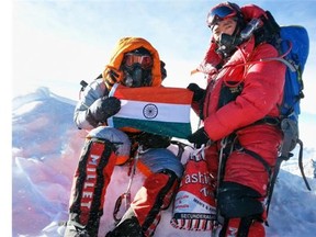 In this Sunday, May 25, 2014 handout photo, Malavath Poorna, left, holds up her nation’s flag on Mount Everest, Nepal. A social charity says the 13-year-old daughter of poor Indian farmers has become the youngest girl to climb Mount Everest. Poorna says she and a team of Nepalese climbing guides made it to the top on May 25 from the northern side in Tibet.