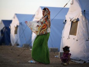 A woman stands outside a tent at a temporary displacement camp set up next to a Kurdish checkpoint on June 13, 2014 in Kalak, Iraq. Thousands of people have fled Iraq’s second city of Mosul after it was overrun by ISIS (Islamic State of Iraq and Syria) militants. Many have been temporarily housed at various IDP (internally displaced persons) camps around the region including the area close to Erbil, as they hope to enter the safety of the nearby Kurdish region.