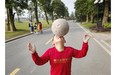 A young Chinese student balances the ball on his nose as he walks to a training match at the Evergrande International Football School on June 14, 2014 near Qingyuan in Guangdong Province, China. The 167-acre campus is the brainchild of property tycoon Xu Jiayin, whose ambition is to train a generation of young athletes to establish China as a football powerhouse.