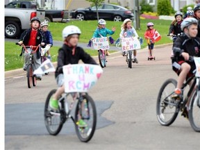 Youngsters take part in a bike rally in the neighbourhood of Rosemont Park in Moncton, N.B. on Saturday, June 7, 2014 in support of the RCMP and their community following a deadly manhunt that forced residents into their homes and basements. RCMP say a man suspected in the shooting deaths of three Mounties and the wounding of two others in Moncton was unarmed at the time of his arrest early Friday and was taken into custody without incident.