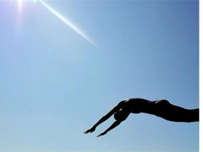 An athlete dives into the water after the first lap of the swim phase during the Women's Triathlon during the 2014 Commonwealth Games at Strathclyde Country Park near Glasgow on July 24, 2014.