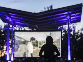 A woman watches the film "Grand Central" outdoors at the Parc de la Promenade-Bellerive during the Cinéma Sous les étoiles event in Montreal on Thursday, July 10, 2014. (Dario Ayala / THE GAZETTE)