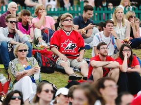 Canadian Darcy Dayment, centre, originally from London, Ont., but who now lives in London, England, watches the women’s singles final between Eugenie Bouchard of Canada and Petra Kvitova of Czech Republic on a large video screen with other spectators at the All England Lawn Tennis Championships in Wimbledon, London Saturday, July 5, 2014.