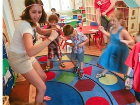 Children at Little Red Playhouse preschool with an educator, left, dance and sing songs on Tuesday.