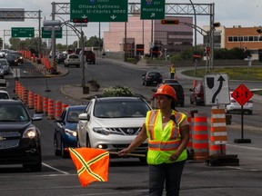 A construction worker directs traffic on St Charles Blvd. just south of Highway 40 on Friday, July 18.