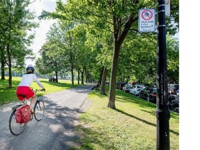 A cyclist rides along the pedestrian path that runs parallel to Jeanne Mance park in Montreal, on Friday, July 11, 2014.