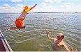 Diego Creimer waits in the water as his four year old son Gaspard jumps off a dock in Verdun.