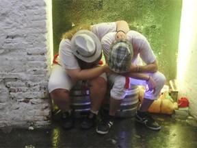 Drunk people rest during the first bull-run of the San Fermin Festival, on July 7, 2014, in Pamplona, northern Spain. The festival is a symbol of Spanish culture that attracts thousands of tourists to watch the bull runs despite heavy condemnation from animal rights groups.