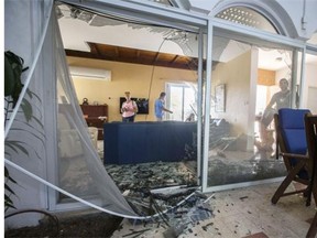 Emergency workers and Israeli security check a house damaged by a rocket fired by militants from the Gaza Strip, on July 16, 2014, in the city of Ashkelon.
