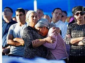 Bat-Galim Shaer (R) and Iris Yifrah (C), the mothers of two of the three Israeli teenagers killed in the West Bank mourn during the funeral of their sons on July 1, 2014 in the cemetery of Modiin in central Israel. Israel paid an emotional farewell to Gilad Shaer and Naftali Frenkel, both 16, and 19-year-old Eyal Ifrach, while vowing to hunt down the Hamas militants it holds responsible for their kidnap and murder.