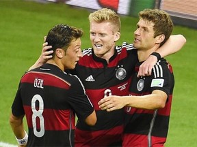 Germany’s forward Andre Schuerrle (C) celebrates after scoring his team’s sixth goal with Germany’s midfielder Mesut Ozil and Germany’s forward Thomas Mueller during the semi-final football match between Brazil and Germany at The Mineirao Stadium in Belo Horizonte on July 8, 2014, during the 2014 FIFA World Cup.
