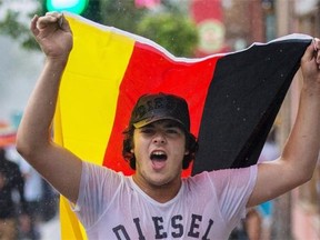 Germany national team fan Anthony Fares waves a German flag as he celebrates on St-Laurent Blvd. in Montreal following the World Cup final match where Germany beat Argentina 1-0 on Sunday. Fares drove from Halifax to Montreal to watch the World Cup game looking for a more exciting atmosphere.