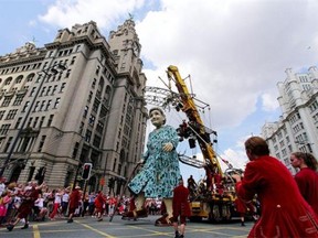 A giant marionette known as the 'Giant Grandmother' is paraded through the streets of Liverpool in north-west England, on July 25, 2014. The parade entitled 'Memories of August 1914' by French theatre company Royal de Luxe, features a giant grandmother, a giant little girl and her dog named Xolo, and tells the story of the city's involvement in World War One.
