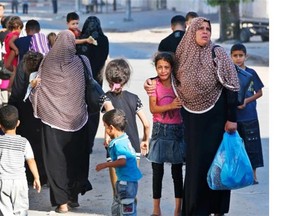 A girl cries as Palestinians flee their homes in the Shajaiyeh neighbourhood of Gaza City, after Israel had airdropped leaflets warning people to leave the area, Wednesday, July 16, 2014.