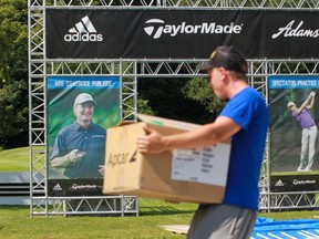 Kristian Miller unloads boxes as several manufacturers that make golf-related items set up booths at The Royal Montreal Golf Club in Ile-Bizard.