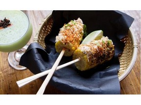 Grilled corn covered in toasted coconut and queso fresco, served with an avocado cocktail at Biiru.
