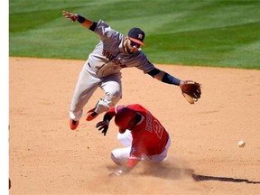 Houston Astros shortstop Marwin Gonzalez, top, cannot reach a ball thrown from home as Los Angeles Angels' Erick Aybar, bottom, steals second during the eighth inning of a baseball game on Sunday, July 6, 2014, in Anaheim, Calif.