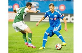Impact’s Krzysztof Krol controls the ball in front of Timbers’ Diego Valeri during first-half action Sunday night in Montreal.