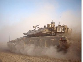 An Israeli tank maneuvers to take a position along the Israel-Gaza Border, Thursday, July 17, 2014. Israel and Hamas have begun observing a five-hour humanitarian cease-fire, as fighting extended into a 10th day. The two sides agreed to the pause following a request by the United Nations so that supplies could be delivered to Gaza.