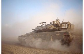 An Israeli tank maneuvers to take a position along the Israel-Gaza Border, Thursday, July 17, 2014. Israel and Hamas have begun observing a five-hour humanitarian cease-fire, as fighting extended into a 10th day. The two sides agreed to the pause following a request by the United Nations so that supplies could be delivered to Gaza.