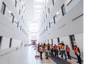 Journalists walk through the atrium of the Block E building at the MUHC superhospital Glen construction site during a media tour in Montreal on Friday, June 27, 2014.