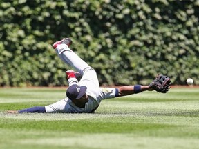 Justin Upton #8 of the Atlanta Braves tries to catch a ball hit by Arismendy Alcantara of the Chicago Cubs in the 1st inning at Wrigley Field on July 13, 2014 in Chicago, Illinois.