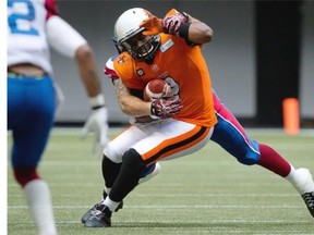 B.C. Lions’ quarterback Kevin Glenn is sacked by Montreal Alouettes’ Gabriel Knapton, back, during the first half of a CFL football game in Vancouver on Saturday July 19, 2014.
