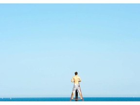 A man looks out to sea, at the beach, in Barcelona, Spain, Thursday, July 17, 2014. Most of Spain is experiencing a heat wave with temperatures reaching around 40 degrees Celsius.