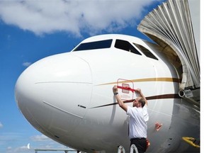A member of ground crew seals a port on an aircraft at the Farnborough air show in Hampshire, England, on July 14, 2014. The biennial event sees leading companies from the aviation industry showcase their latest technology.