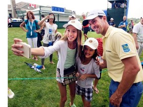Mike Weir, from Brights Grove, Ont., poses for a selfie with Kaylee Chin, left, and Maya Cunningham, centre, during the pro-am event at the Canadian Open golf championship Wednesday, July 23, 2014 at Royal Montreal golf club in Montreal.