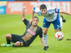 Montreal Impact’s Karl Ouimette, right, is brought down by Philadelphia Union’s Danny Cruz during first half MLS soccer action in Montreal, Saturday, April 26, 2014.