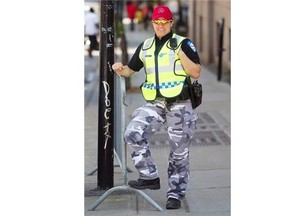 Montreal police officer dressed in camo pants and red cap.