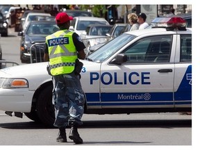 Montreal police officer dressed in camo pants and red cap, during Carifiesta parade on Saturday July 5, 2014. Police switched over from their traditional uniforms to protest proposed pension fund modifications by the Couillard government.