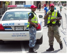 Montreal police officers dressed in camo pants and red cap, during Carifiesta parade to protest proposed modifications to their pension funds.