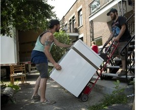Left to right, movers Charles Lalonde and Alexis Gaudet move a dryer down a second floor apartment on de Bordeaux street in Montreal, Tuesday July 1, 2014.