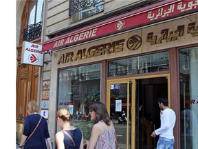 Passersby walk past the Air Algerie company office, on the Opera Avenue in Paris Thursday July 24, 2014. A Montreal-area family was aboard the Air Algérie flight that crashed in northern Mali Thursday, according to media reports.