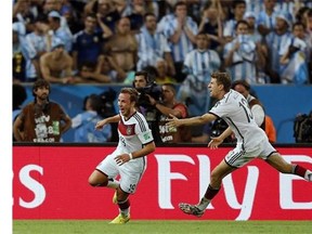 Germany's Mario Goetze, left, celebrates with Thomas Mueller after scoring the opening goal during the World Cup final soccer match between Germany and Argentina at the Maracana Stadium in Rio de Janeiro, Brazil, Sunday, July 13, 2014. Germany beat Argentina 1-0 to win its fourth World Cup title. (AP Photo/Frank Augstein)