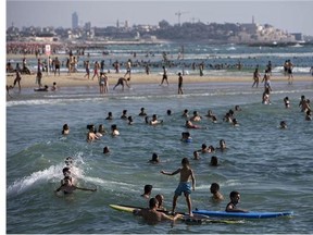 Israelis and tourists enjoy the Mediterranean Sea beachfront during a humanitarian cease-fire in the Gaza war, in Tel Aviv, Israel, Saturday, July 26, 2014.