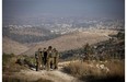 Israeli soldiers patrol near the area where the bodies of three Israeli teenagers were found, in the village of Halhul, near the West Bank city of Hebron, Tuesday, July 1, 2014.